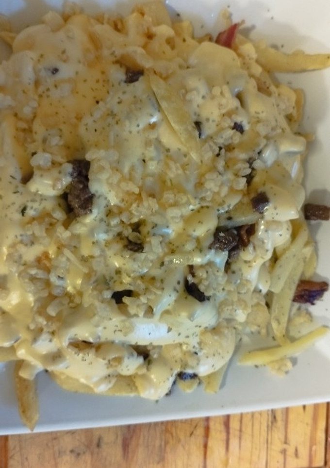 Una foto de Chorrillana a mi estilo (con tocino carne y salsa de queso)