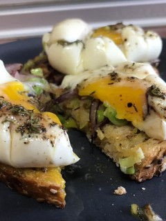 Una foto de Huevos Touché! Tosta de huevos poché, sobre ajo puerro y cebolla morada