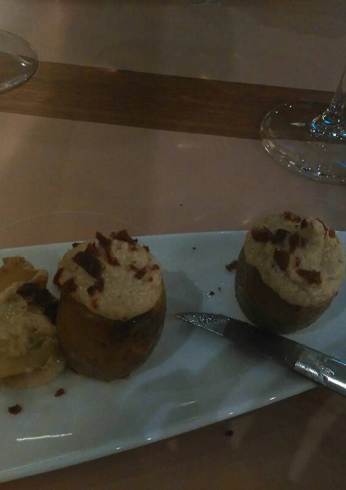 Una foto de Patatas rellena de salsa de queso y jamón crujiente