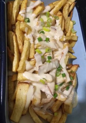 Una foto de Papas fritas con salsa de quesos