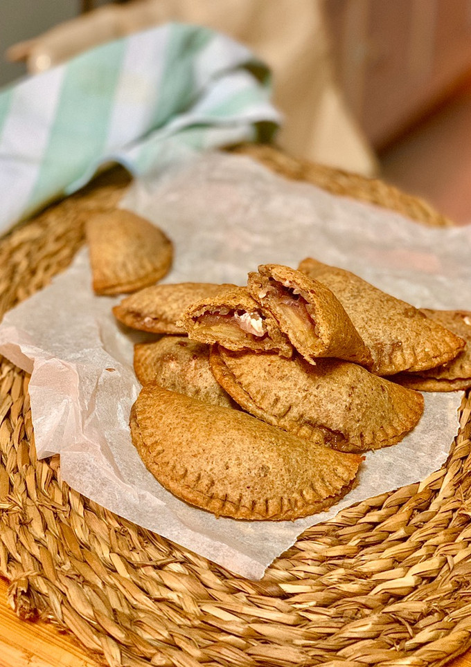 Una foto de Empanadillas con masa de centeno integral y relleno de cebolla caramelizada, manzana y feta