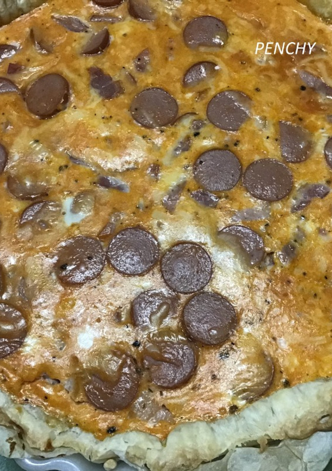 Una foto de Pastel de hojaldre con salchichas al queso, bacon y tomate frito