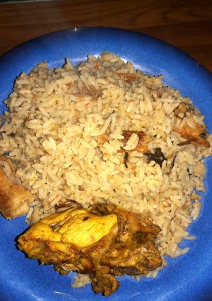 A picture of Coconut rice with dry fish and chicken.