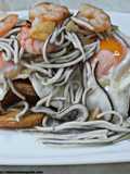 Huevos rotos con patatas, gulas y gambas