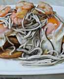 Huevos rotos con patatas, gulas y gambas