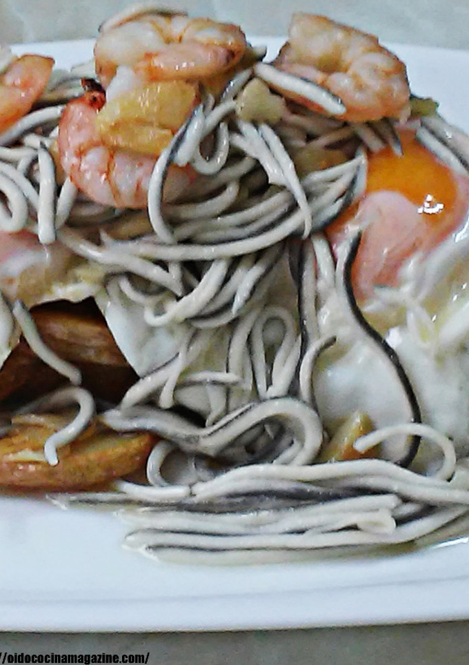 Una foto de Huevos rotos con patatas, gulas y gambas