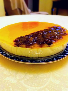 Una foto de Tarta de queso, limón y vainilla con glaseado de pasas al ron