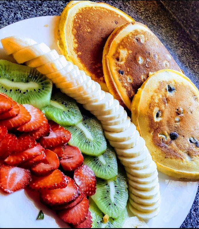 Una foto de Hot cakes con fruta🥞🍌🥝🍓