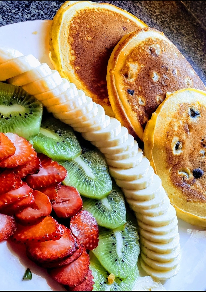 Una foto de Hot cakes con fruta🥞🍌🥝🍓