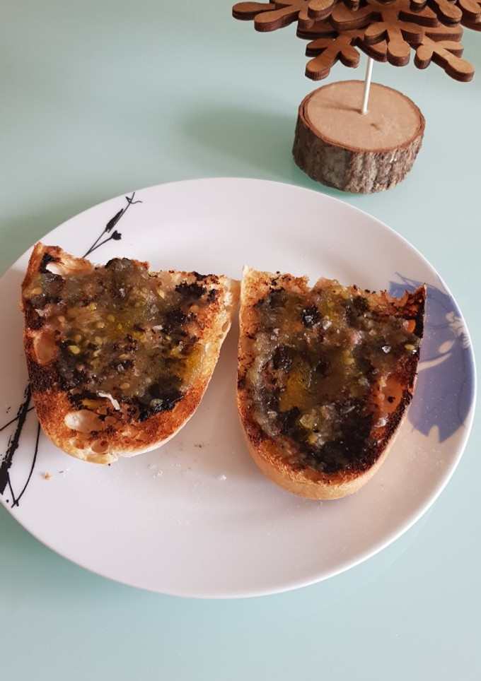 Una foto de Tosta de ajo negro y tomate