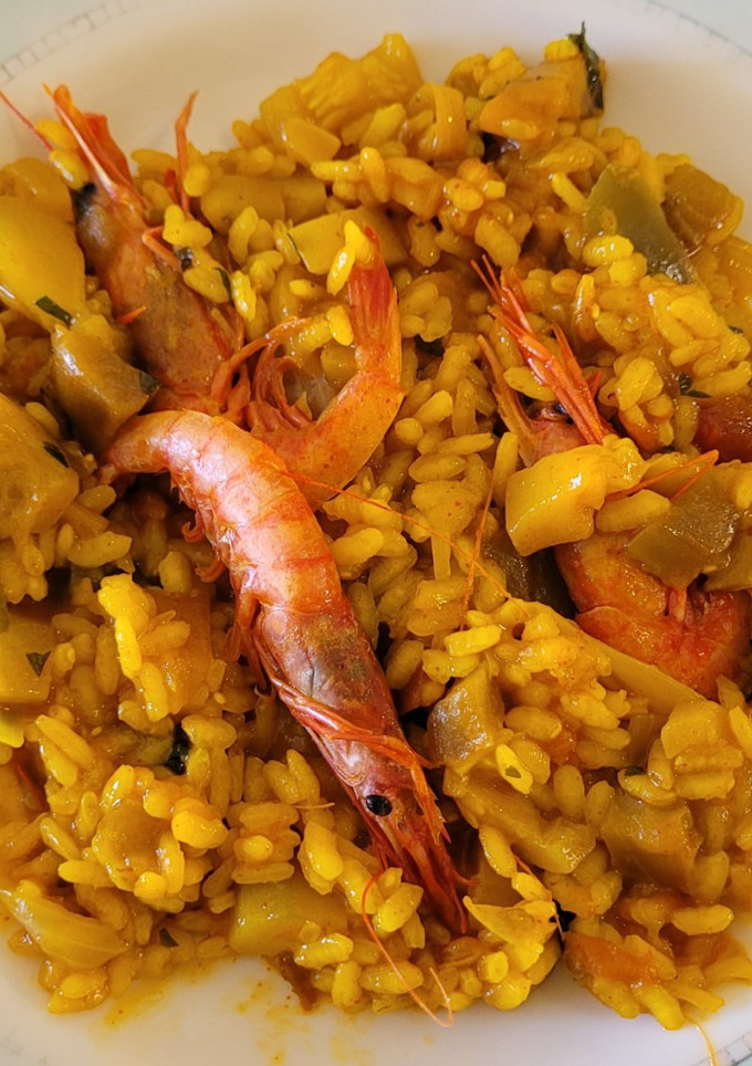 Una foto de Paella con pisto y gambas en un plis plas