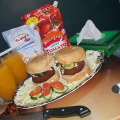 A picture of Reshmi kabab burger with orange juice.