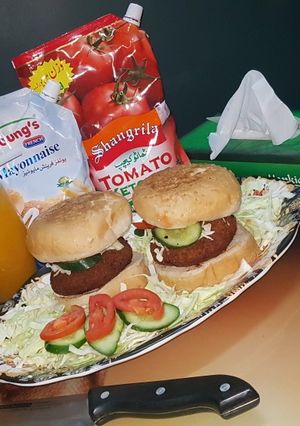 A picture of Reshmi kabab burger with orange juice.