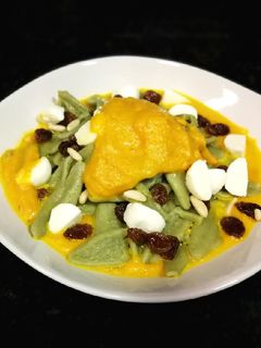 Una foto de Pasta de espinaca sobre puré de zanahoria