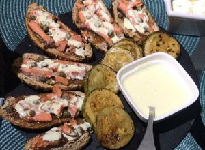 Una foto de Tabla de tapas de salmón y alcaparras, zapallos italianos asados y salsa alioli
