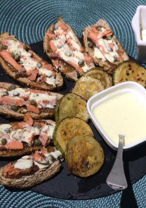 Una foto de Tabla de tapas de salmón y alcaparras, zapallos italianos asados y salsa alioli