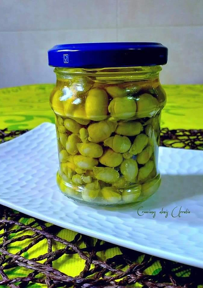 Una foto de Lágrimas y yemas de vainas de habas en aceite de oliva y Romero