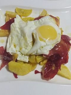 Una foto de Huevos rotos con jamón