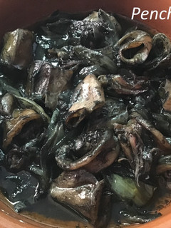 Una foto de Chipirones negros encebollados