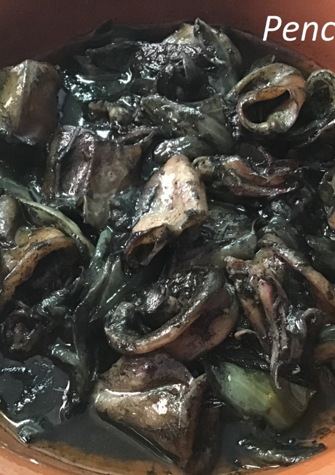 Una foto de Chipirones negros encebollados