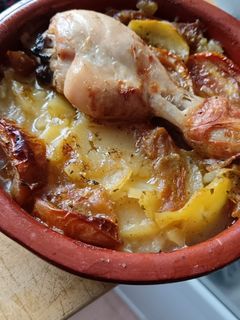 Una foto de Muslo de pollo al horno con patatas y tomate