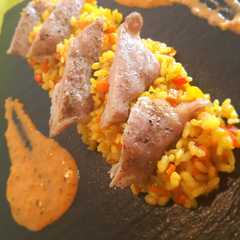 Una foto de Arroz a la cúrcuma con secreto ibérico y salsa mojo