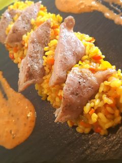 Una foto de Arroz a la cúrcuma con secreto ibérico y salsa mojo