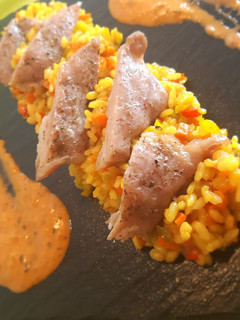 Una foto de Arroz a la cúrcuma con secreto ibérico y salsa mojo