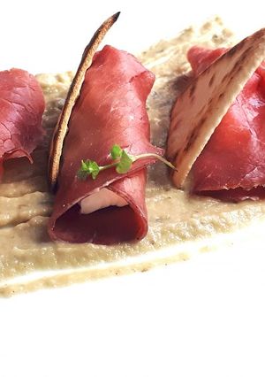 Foto di Involtini di bresaola e caprino su tiepidina di melanzane