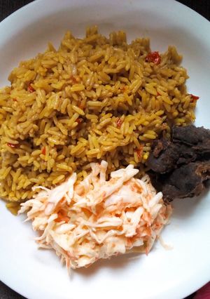 A picture of Jollof rice with coleslaw.