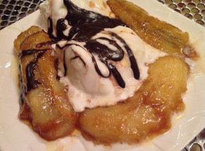 A picture of Caramelized Banana splits with chocolate sauce.