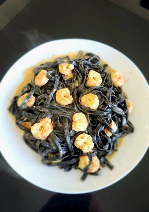 Una foto de Fideos frescos en tinta de Calamar con Langostinos dorados a la manteca