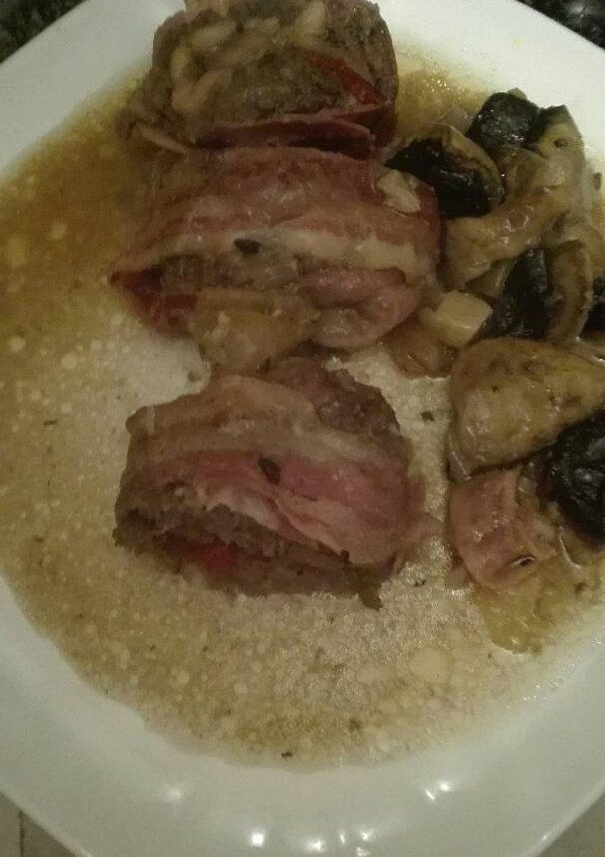 Una foto de Rollo de carne picada rellena en salsa con champiñones, pollo y piquillos