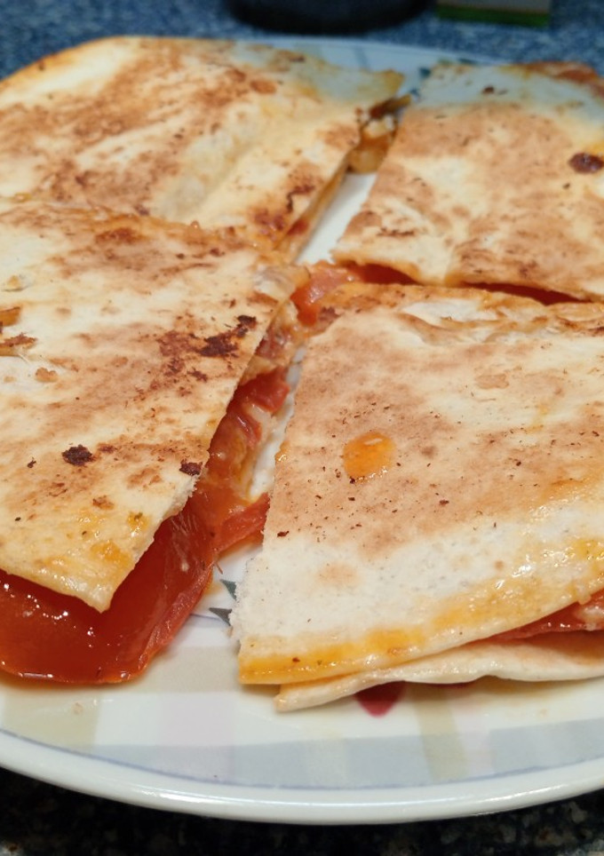 Una foto de Tortilla de trigo con tomate y queso 🍅🧀