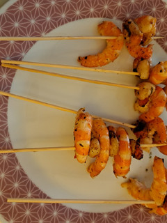 Una foto de Brocheta de langostinos con vieiras al ajillo