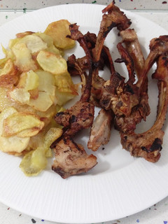 Una foto de Barbacoa de chuletillas de cordero con patatas fritas