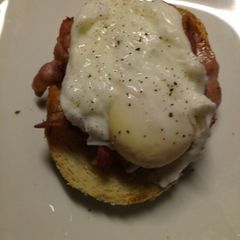 A picture of Pancetta and poached egg on toasted oregano bread.