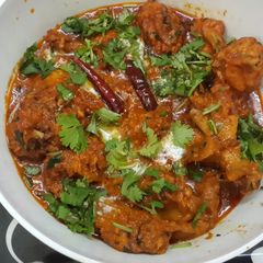 A picture of Coconut chicken with fresh methi leaves.