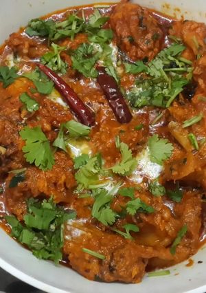 A picture of Coconut chicken with fresh methi leaves.