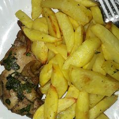 A picture of Baked chicken served with fries.