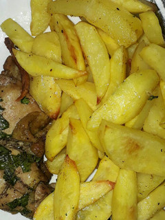 A picture of Baked chicken served with fries.