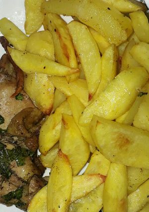 A picture of Baked chicken served with fries.