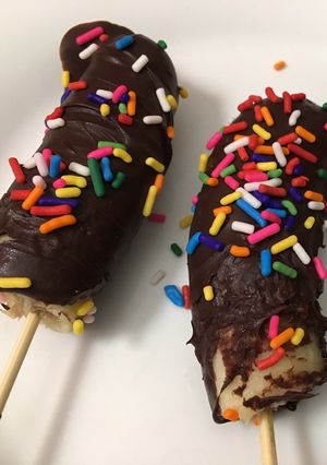 A picture of Kids treat frozen chocolate bananas 🍌.