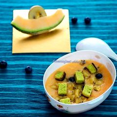 A picture of Muskmelon soup topped with green tea cake croutons.