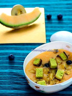 A picture of Muskmelon soup topped with green tea cake croutons.