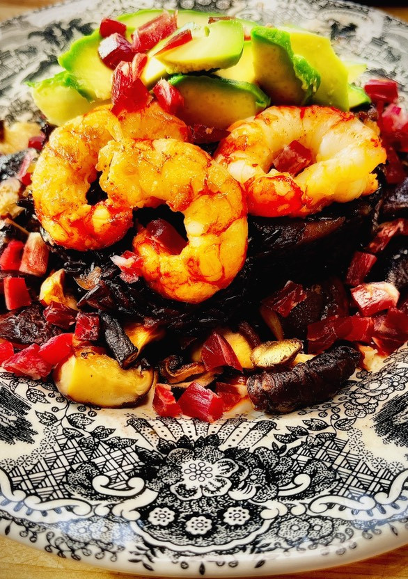 Una foto de Arroz venere con langostinos, shiitake y jamón ibérico