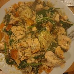 A picture of Salmon with courgettes spinach and orange bell pepper.