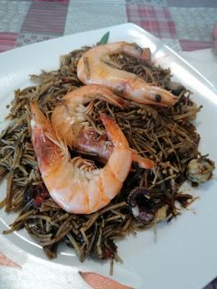 Una foto de 148. Fideuà negra con langostinos