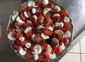 Une photo de Salade de tomates aux billes de mozzarella ciboulette et crème de balsamique