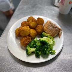 A picture of Spanish rice balls with sliced Turkey and sauté broccoli.